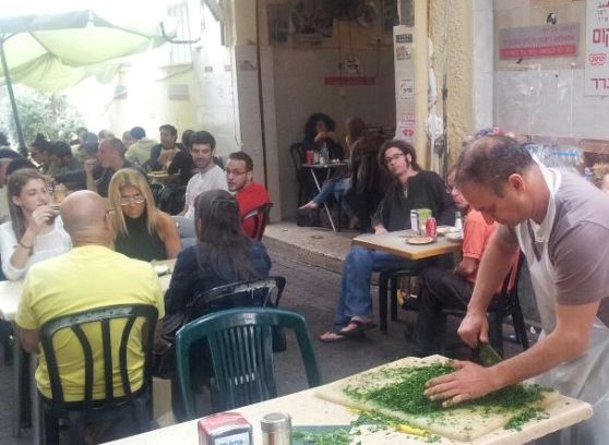 chopping fresh parsley at Shlomo and Doron Hummus in Tel Aviv chopping fresh parsley at Shlomo and Doron Hummus in Tel Aviv