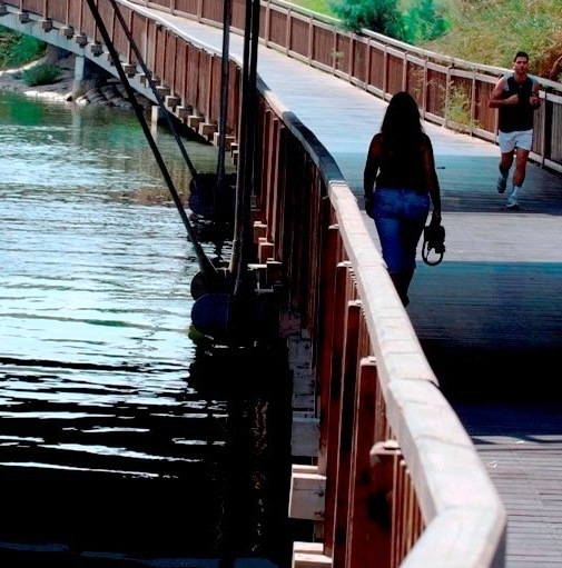 Jogging and walking along a bridge in Tel Aviv's beautiful Yarkon Park