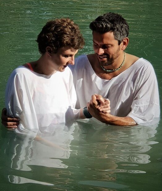 Tourists undergo a baptism in the Jordan River on a private tour with Levi of Go-TelAviv tours